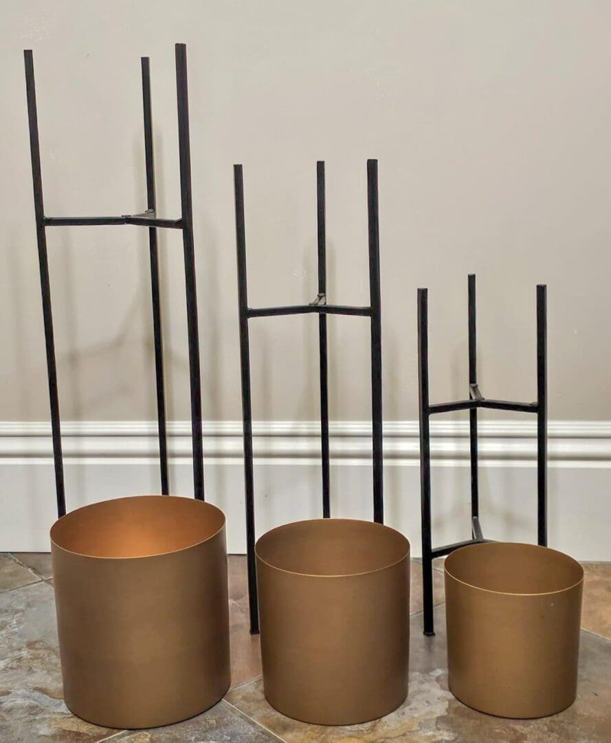 Three different sized pots with a metal rod in the middle.