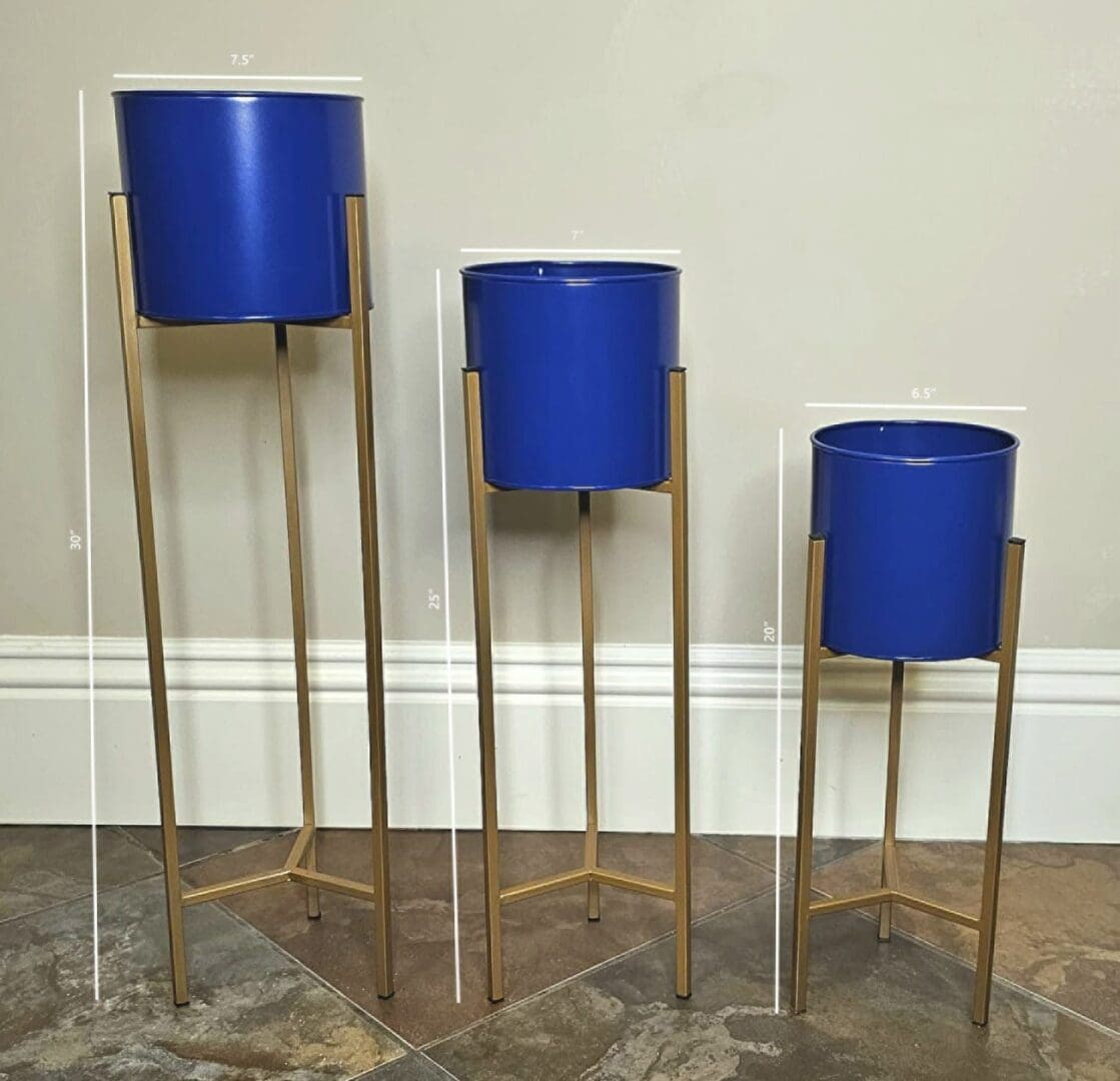 Three blue planters are on stands in a room.
