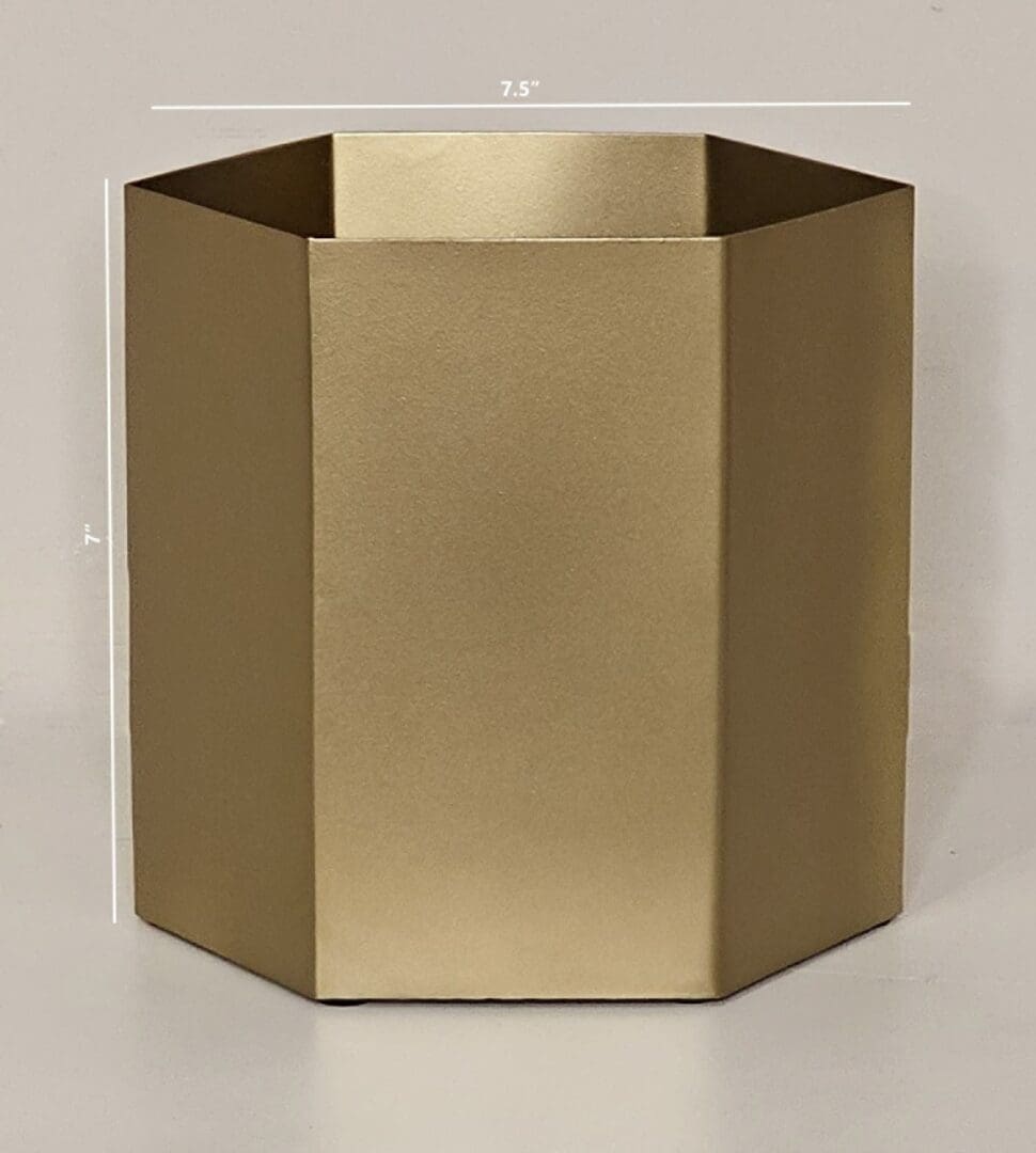 A gold colored metal container sitting on top of a table.