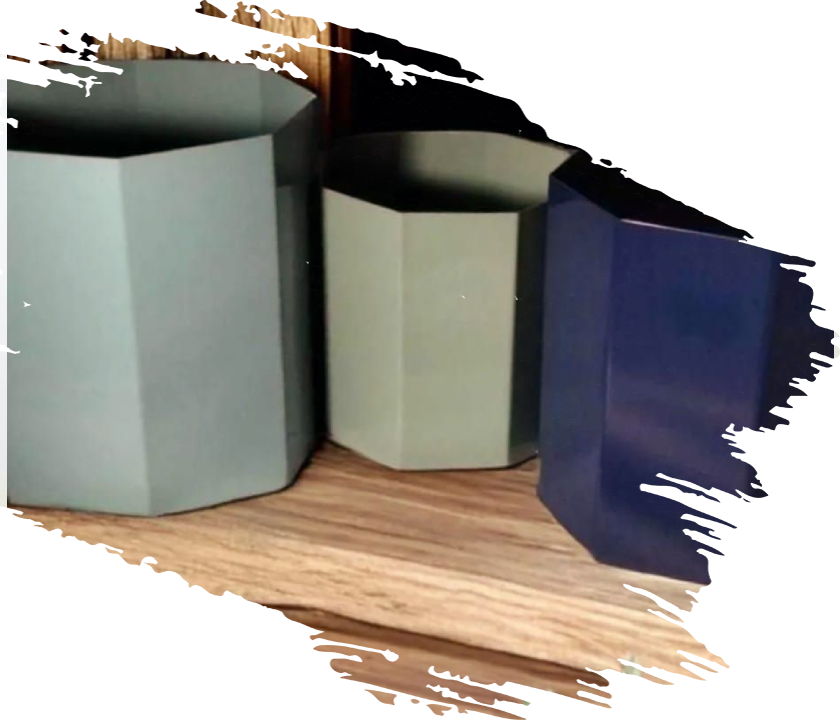 A group of three different colored containers on top of a wooden floor.