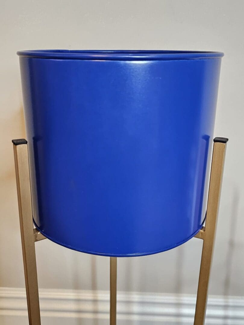 A blue bucket sitting on top of a wooden stand.