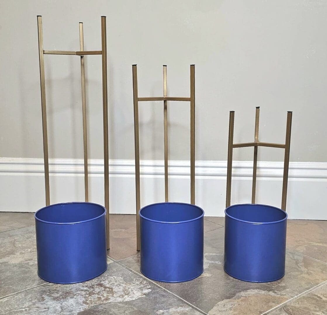 Three blue pots with a plant stand in the middle.