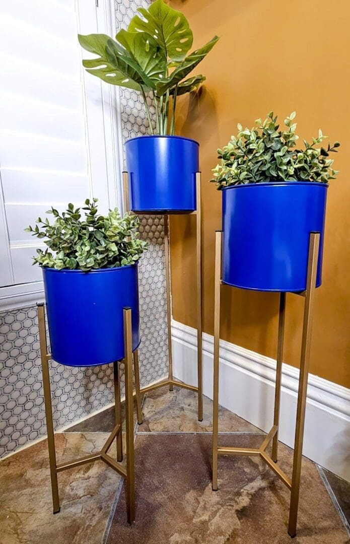 Three blue planters are on a stand.
