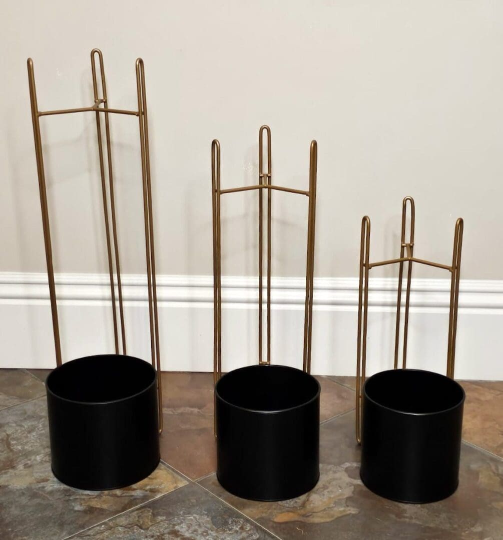 Three black pots with metal rods in them.