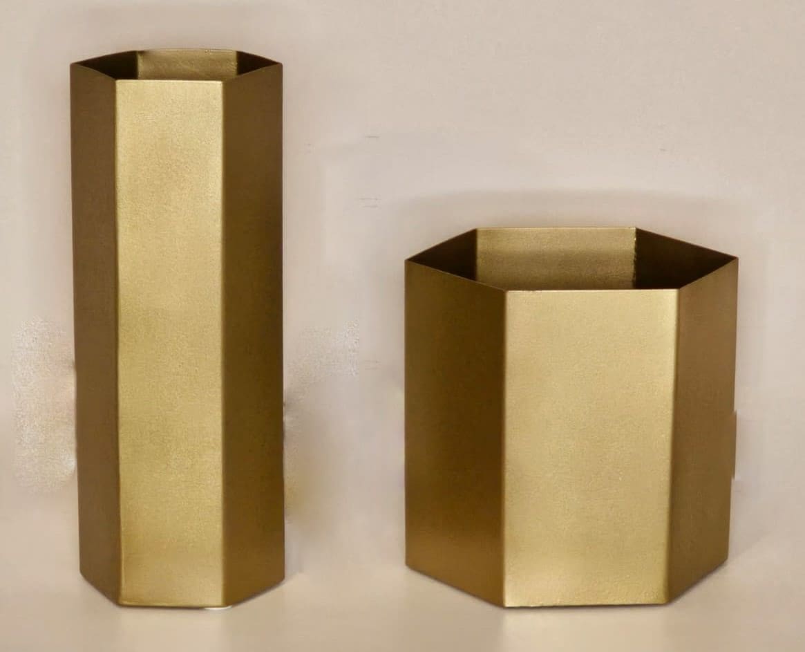 Two gold vases are sitting on a table.